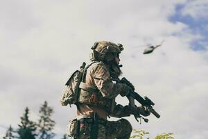 conceito de guerra. um soldado barbudo em um uniforme das forças especiais lutando contra um inimigo em uma área de floresta. foco seletivo foto