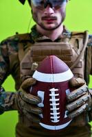 solda segurando uma bola de futebol americano foto