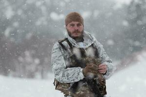 guerra de inverno nas montanhas árticas. operação em condições frias. soldado no uniforme camuflado de inverno no exército de guerra moderna em um dia de neve no campo de batalha da floresta com um rifle. foco seletivo foto