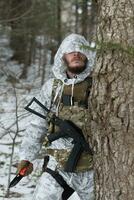 guerra de inverno nas montanhas árticas. operação em condições frias. soldado no uniforme camuflado de inverno no exército de guerra moderna em um dia de neve no campo de batalha da floresta com um rifle. foco seletivo foto