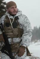 guerra de inverno nas montanhas árticas. operação em condições frias. soldado no uniforme camuflado de inverno no exército de guerra moderna em um dia de neve no campo de batalha da floresta com um rifle. foco seletivo foto