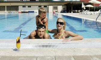 feliz jovem família se divertir na piscina foto