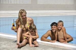 feliz jovem família se divertir na piscina foto