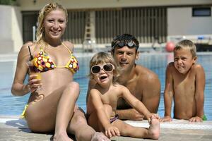 feliz jovem família se divertir na piscina foto