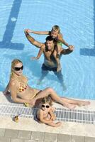 feliz jovem família se divertir na piscina foto