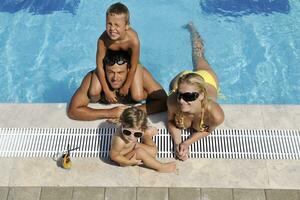 feliz jovem família se divertir na piscina foto