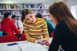 grupo de estudantes trabalhando no projeto escolar juntos no computador tablet na universidade moderna foto