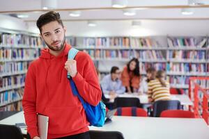 o aluno usa um laptop e uma biblioteca escolar foto