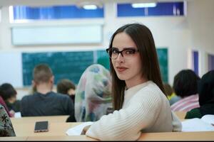 menina sentada em um anfiteatro e conversando com seus colegas foto