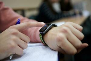 o aluno usa um smartwatch na aula de matemática foto