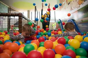 jovem mãe com seus filhos em uma sala de jogos infantil foto