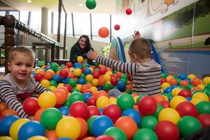 jovem mãe com seus filhos em uma sala de jogos infantil foto