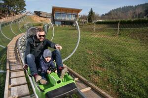 pai e filho gostam de dirigir na montanha-russa alpina foto