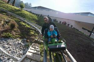 pai e filho gostam de dirigir na montanha-russa alpina foto