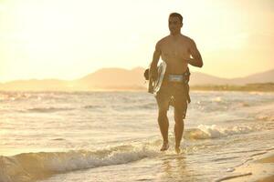 retrato de um jovem kitsurf na praia ao pôr do sol foto