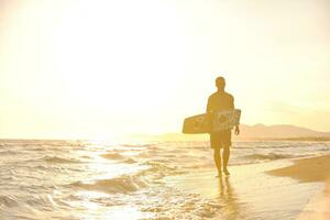 retrato de um jovem kitsurf na praia ao pôr do sol foto