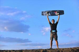 retrato de um jovem kitsurf na praia ao pôr do sol foto