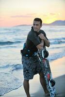 retrato de um jovem kitsurf na praia ao pôr do sol foto