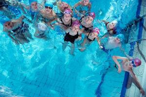 grupo de crianças felizes na piscina foto