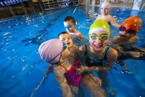 .feliz momentos às natação piscina com sorrindo crianças foto