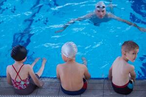 grupo infantil na aula de piscina foto