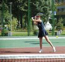 jovem joga tênis ao ar livre foto