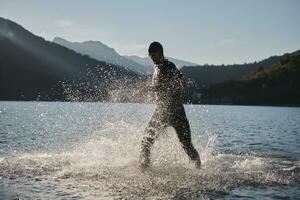 atleta de triatlo iniciando treinamento de natação no lago foto