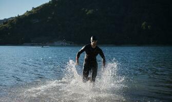 atleta de triatlo iniciando treinamento de natação no lago foto