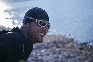 atleta de triatlo iniciando treinamento de natação no lago foto