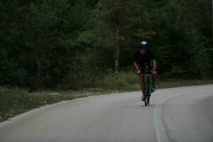 atleta de triatlo andando de bicicleta vestindo preto foto