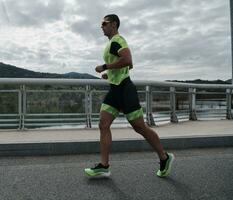 atleta de triatlo correndo na rua foto