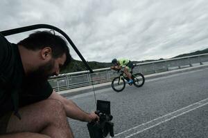 cinegrafista levando açao tiro do triatlo bicicleta atleta foto