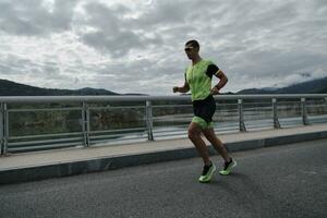 atleta de triatlo correndo na rua foto