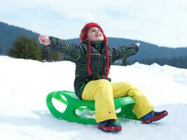 menino feliz se diverte nas férias de inverno na neve fresca foto