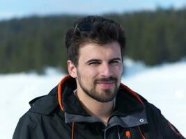 retrato do jovem homem com barba e oculos de sol em fresco neve foto