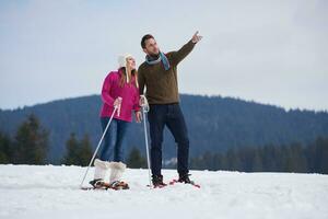 casal se divertindo e andando com sapatos de neve foto