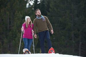 casal se divertindo e andando com sapatos de neve foto