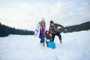 família feliz jogando juntos na neve no inverno foto