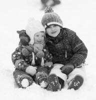 grupo de crianças se divertindo e brincando juntos na neve fresca foto