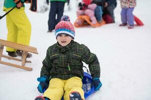 grupo de crianças se divertindo e brincando juntos na neve fresca foto