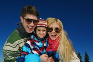 família se divertindo na neve fresca no inverno foto