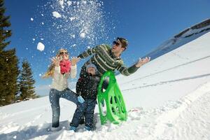 família se divertindo na neve fresca no inverno foto