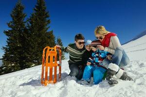 família se divertindo na neve fresca nas férias de inverno foto