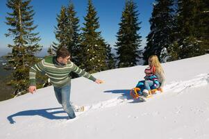 família se divertindo na neve fresca no inverno foto