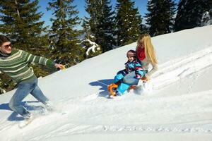 família se divertindo na neve fresca no inverno foto