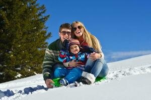 família se divertindo na neve fresca no inverno foto