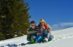 família se divertindo na neve fresca nas férias de inverno foto