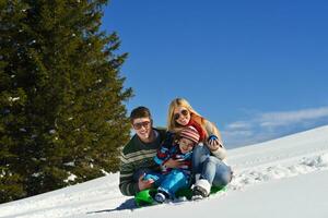 família se divertindo na neve fresca no inverno foto