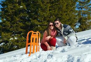 família se divertindo na neve fresca no inverno foto