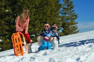 família se divertindo na neve fresca nas férias de inverno foto